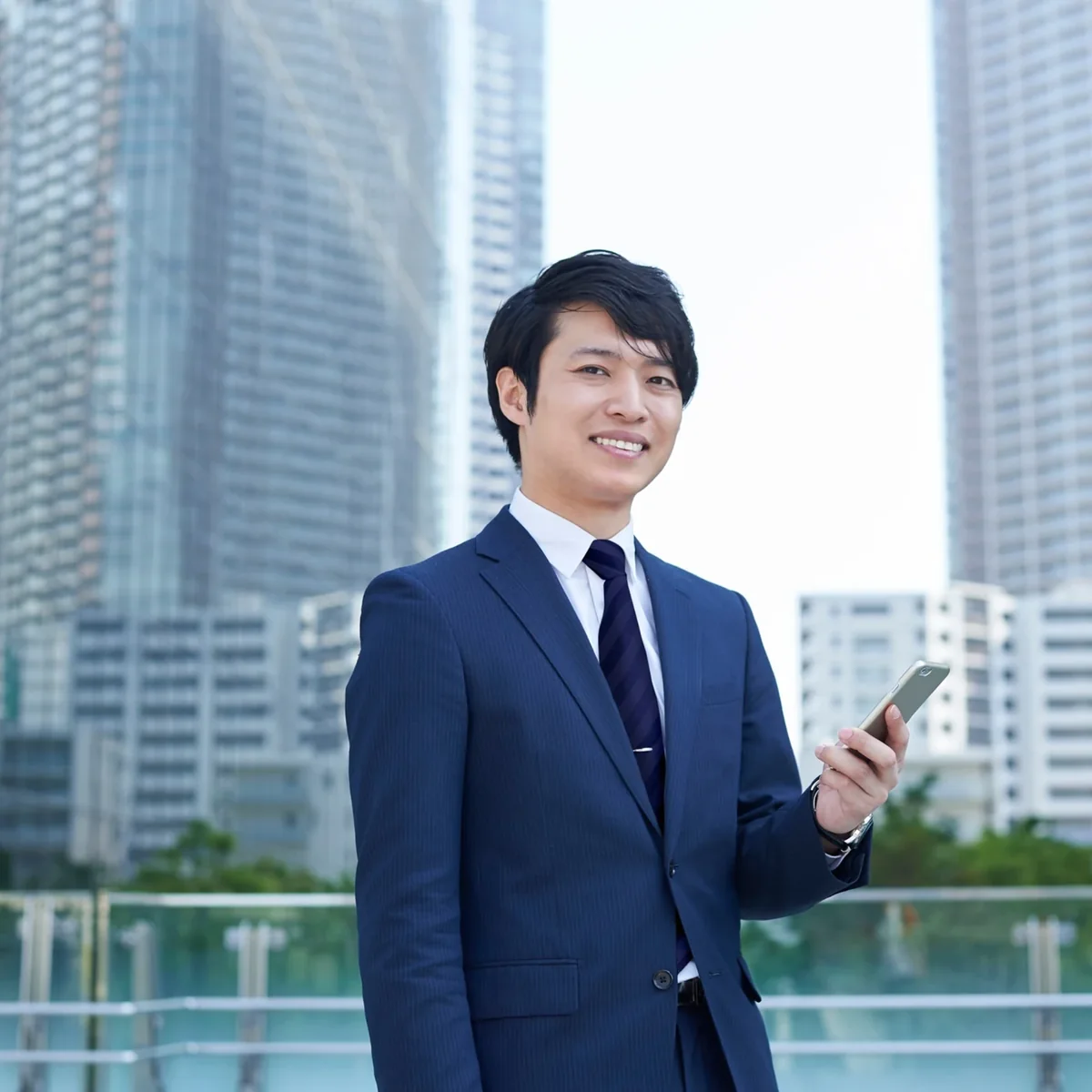 A professional standing beside a window overlooking city buildings
