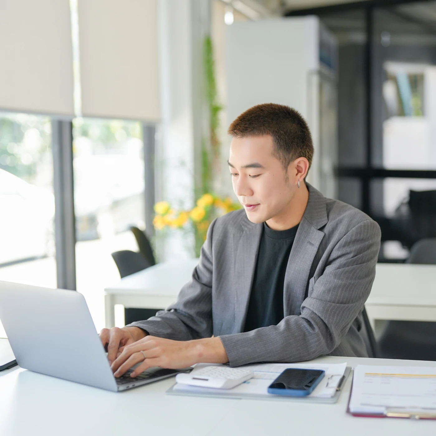 Professional working on a laptop at a desk.