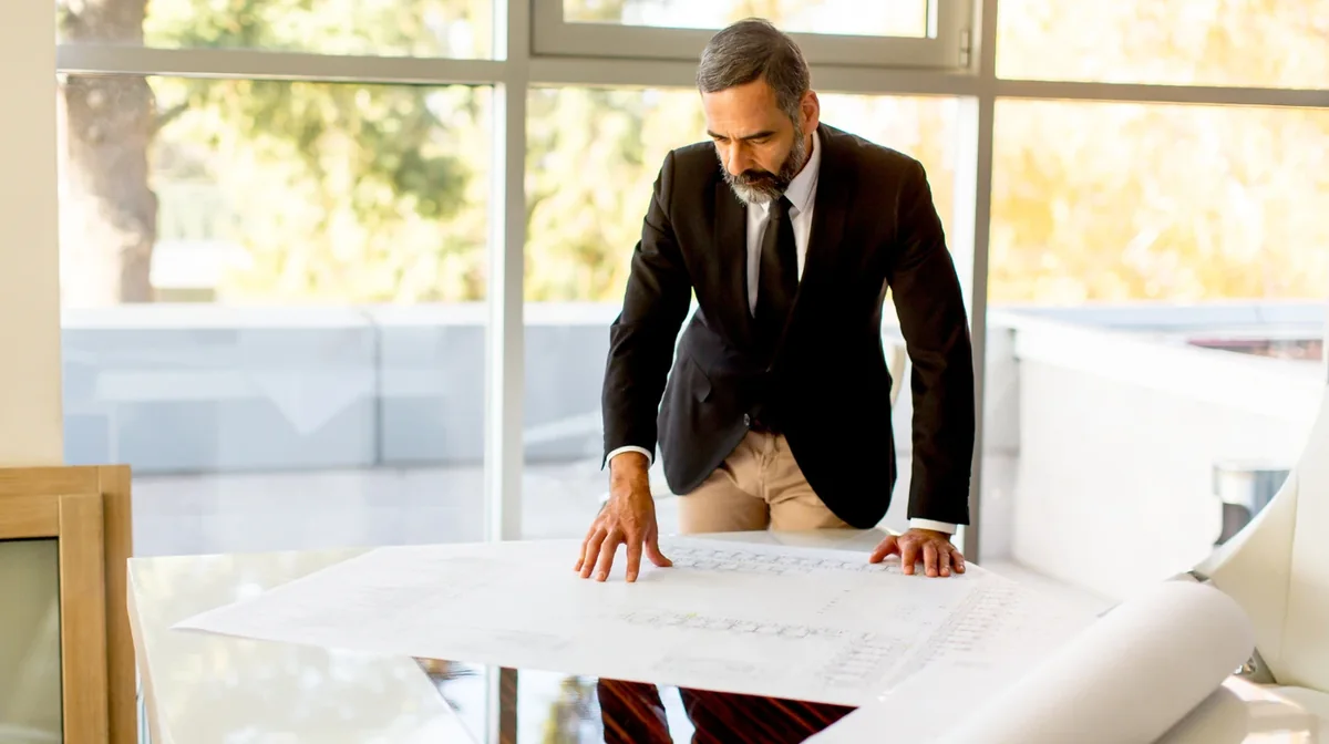 A professional reviewing plans in a bright workspace