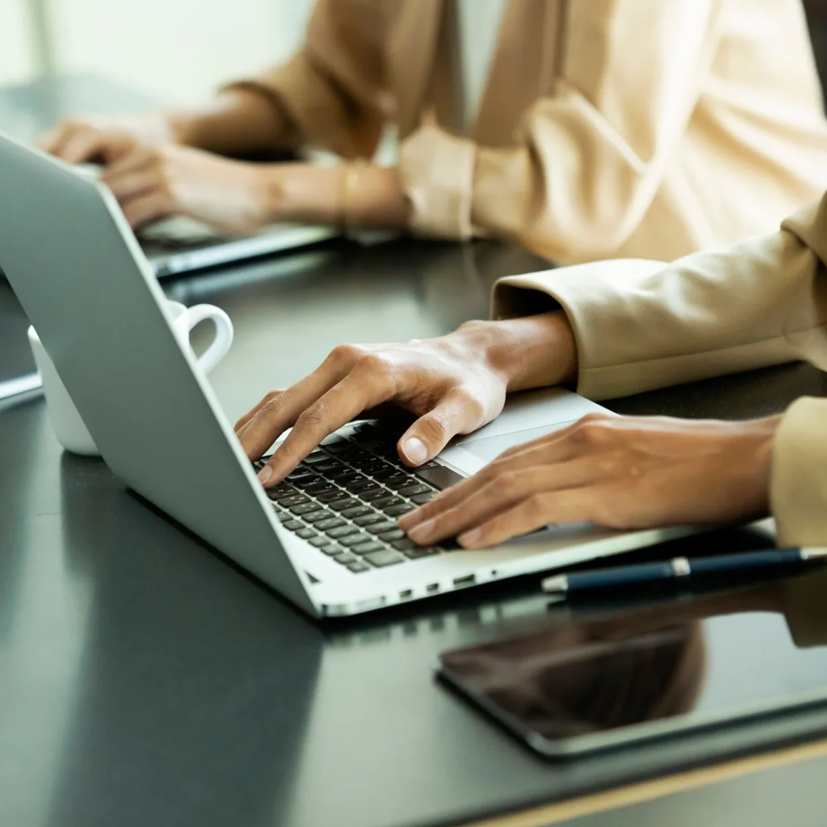 Hands working on a laptop keyboard