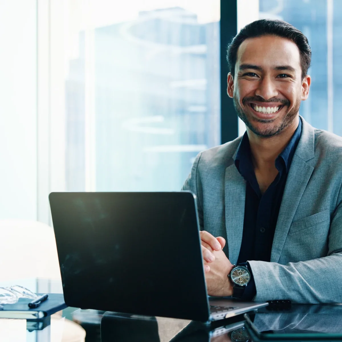 A smiling professional working at a laptop