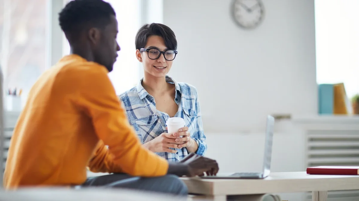 Two colleagues discussing work at a computer