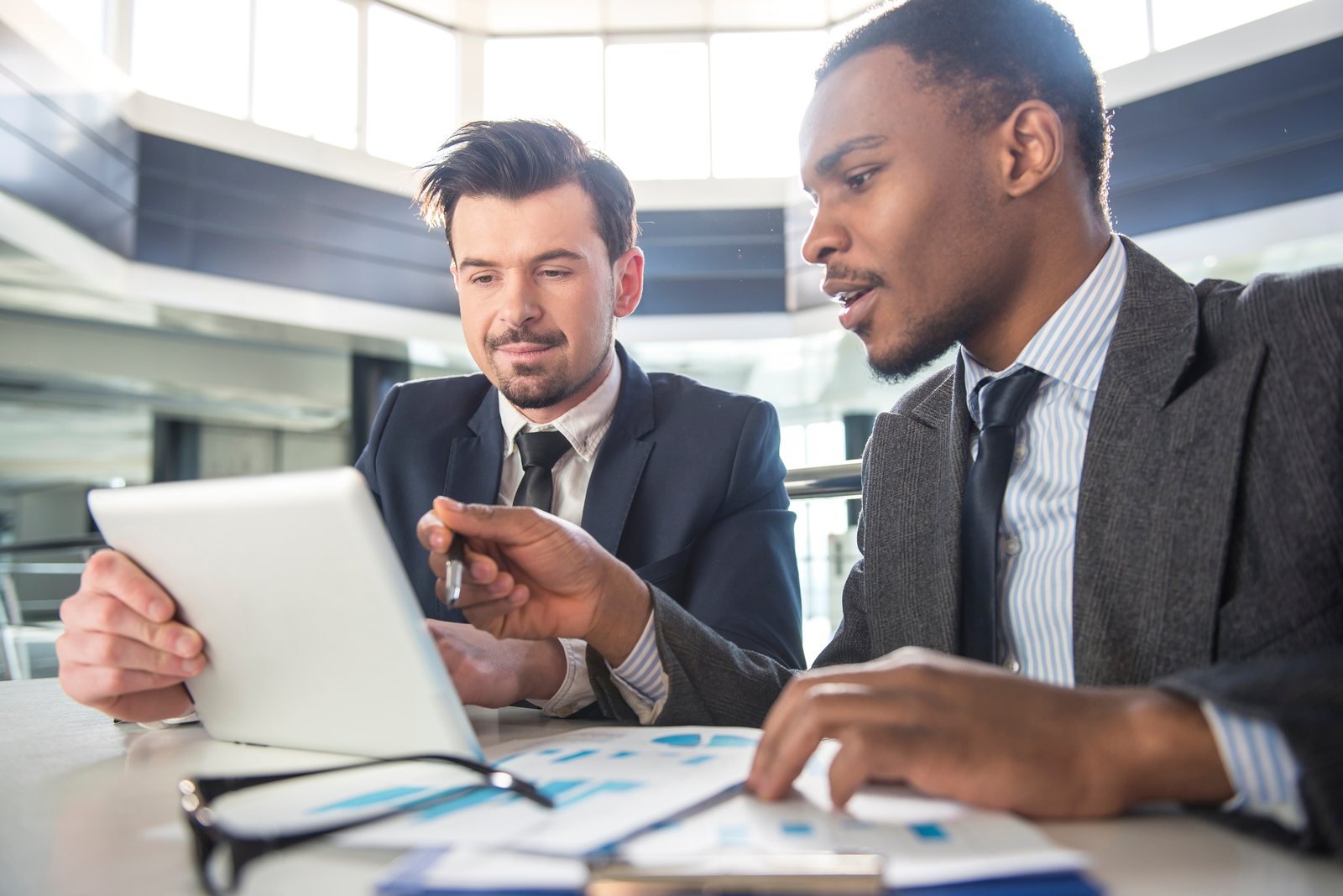 Professionals collaborating over a tablet in an office