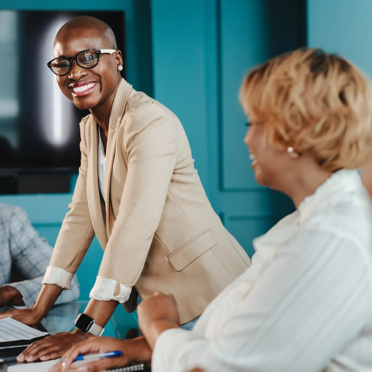 A professional speaking with a colleague across a desk